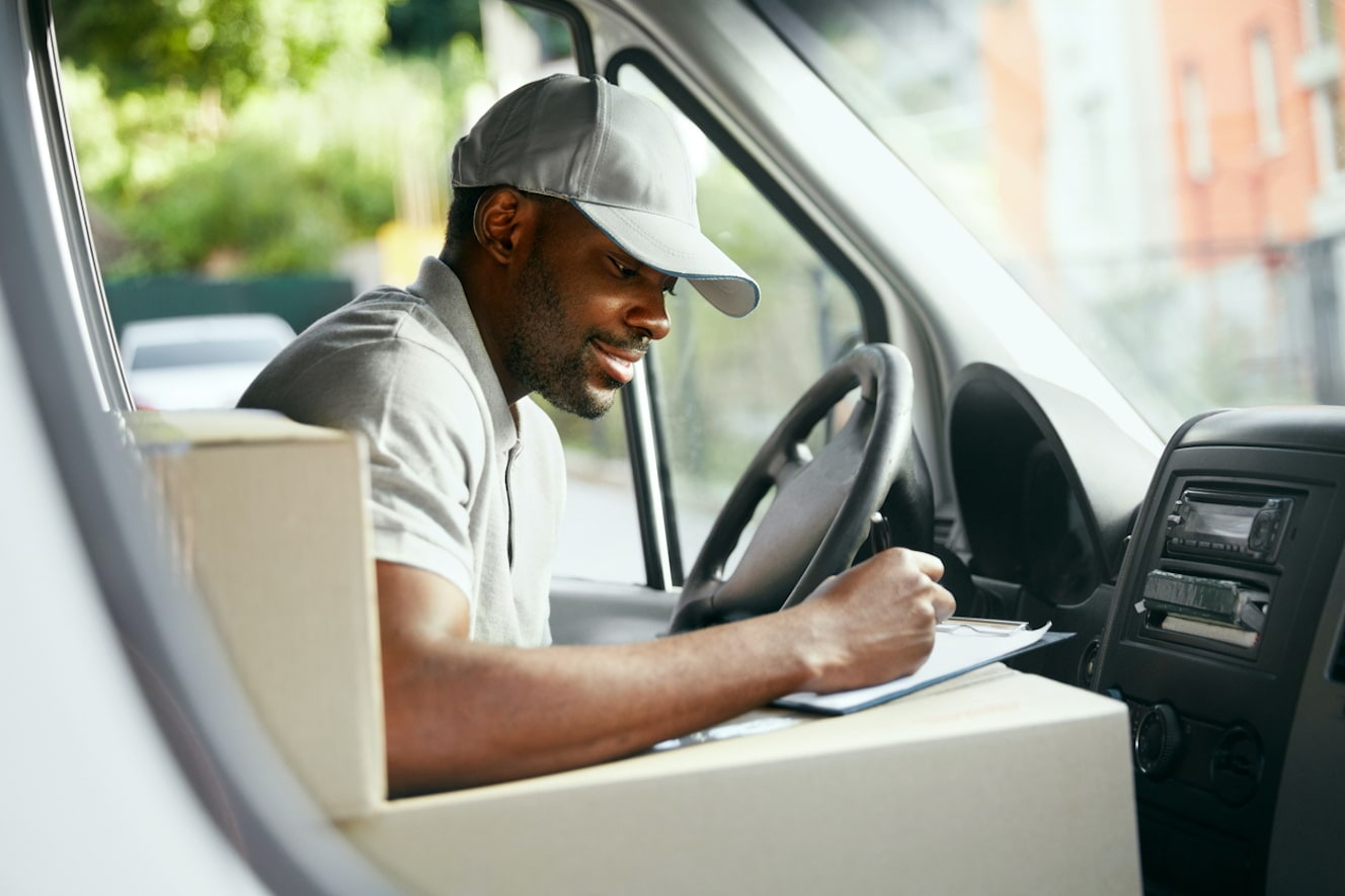 Delivery driver writes on a clipboard