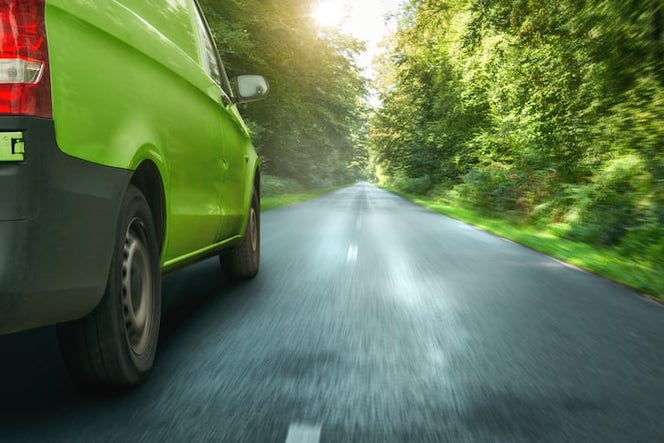 Green Delivery Van Driving Through Forest