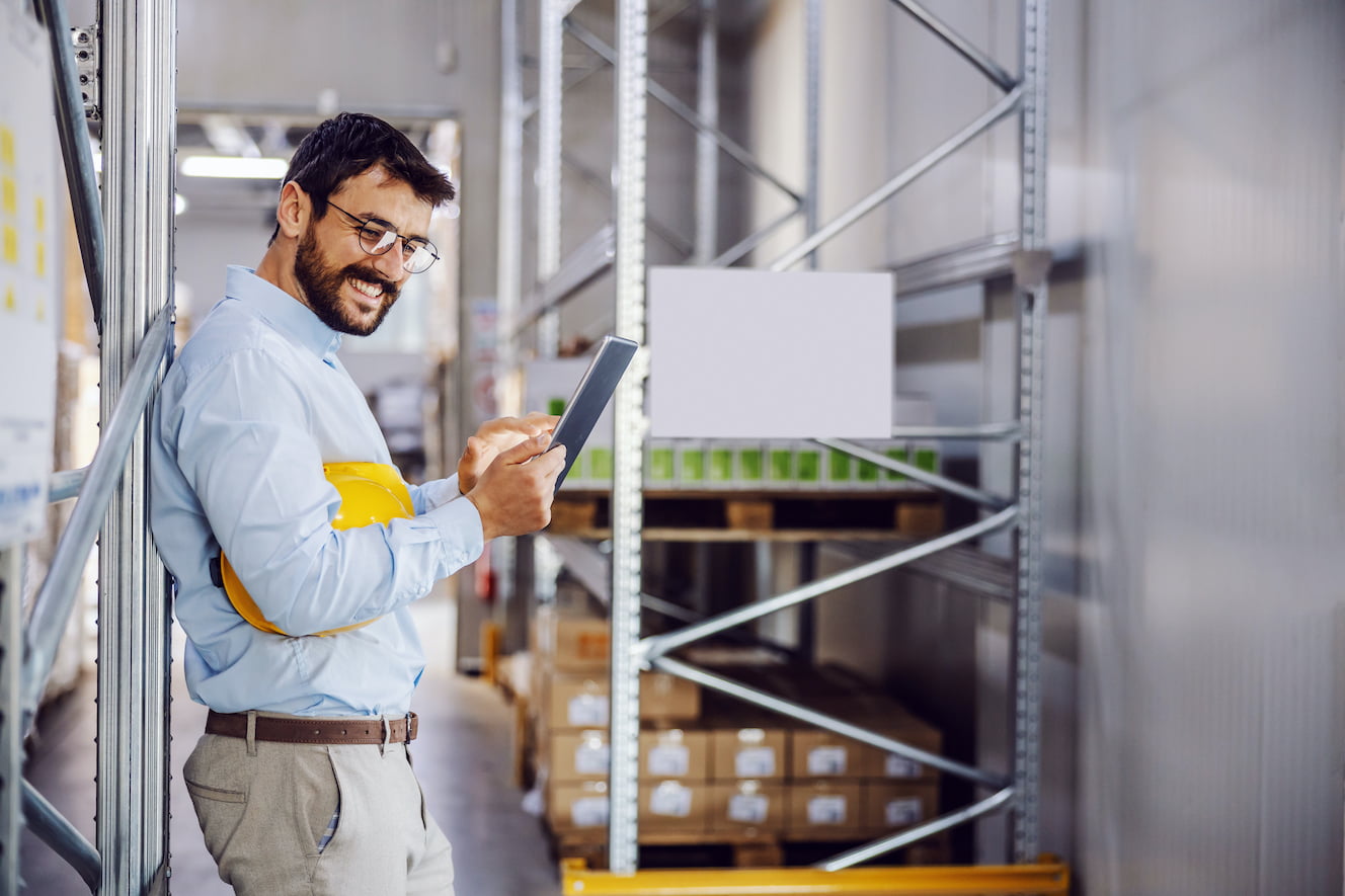 Person in warehouse on tablet smiling