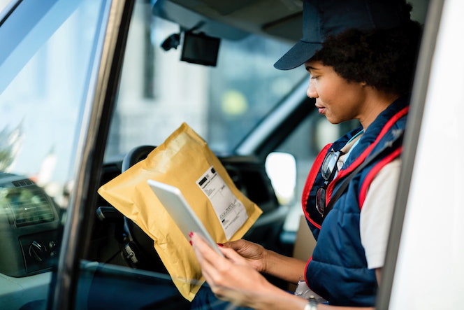 Mail Carrier Check Package Against Tablet