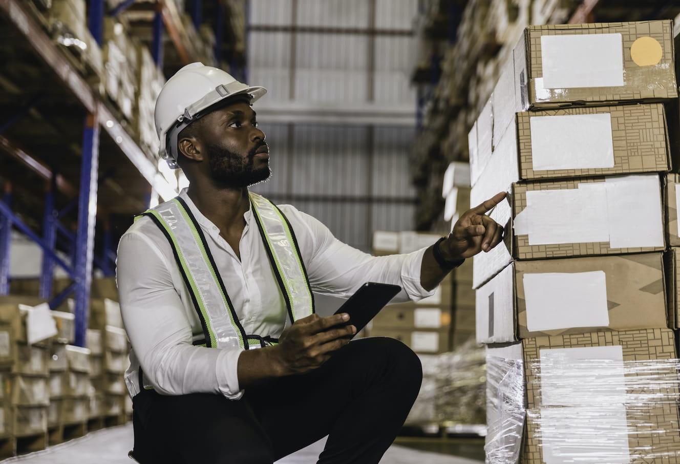 Man in a warehouse counting packages