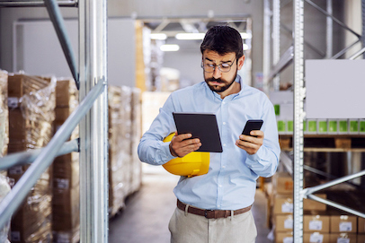 Person in Warehouse with Tablet and Phone
