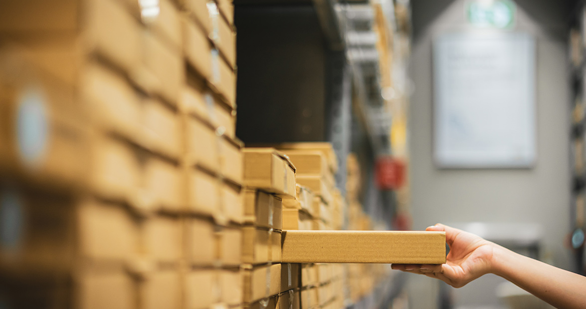 person placing package onto sorted stack