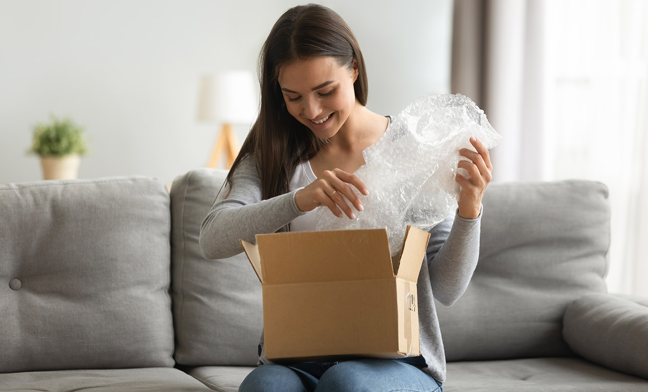 Person pulling bubblewrap out of box