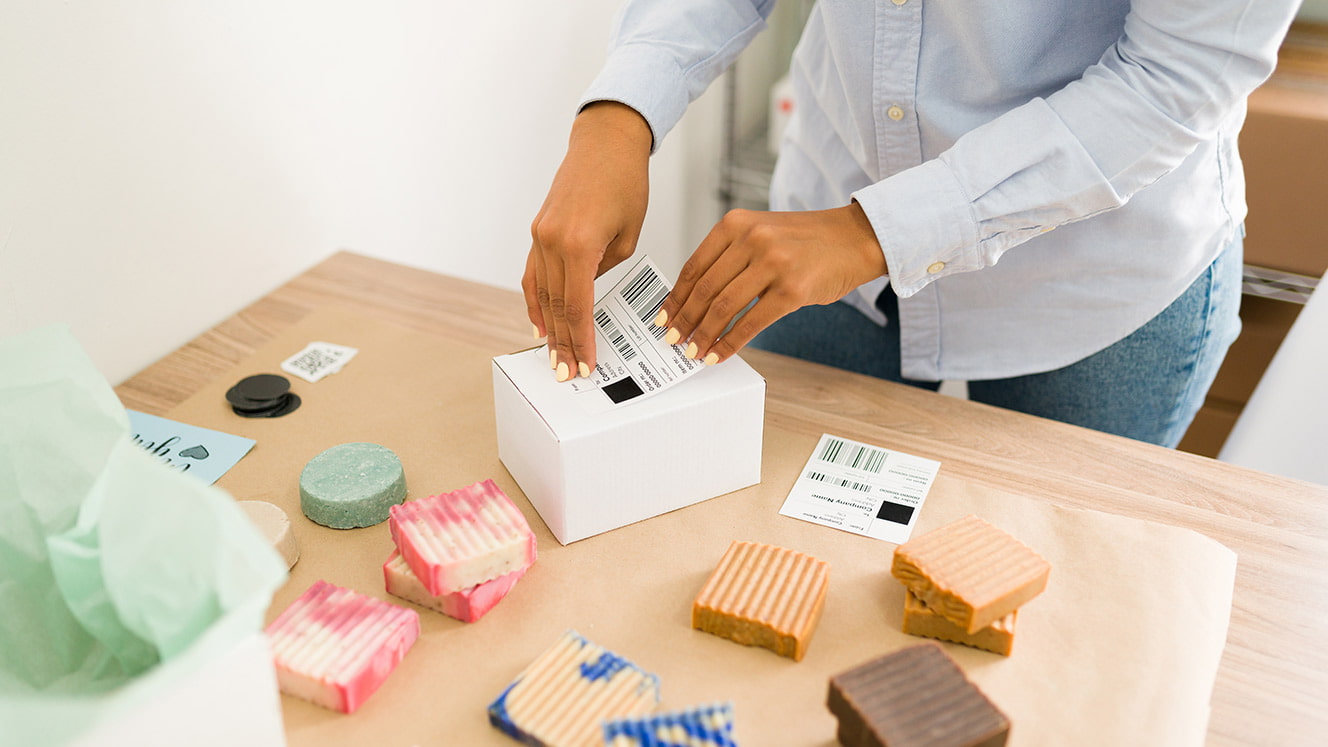 Person packing homemade soaps to ship