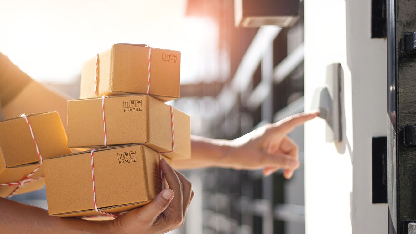 Person holding stack of fragile boxes