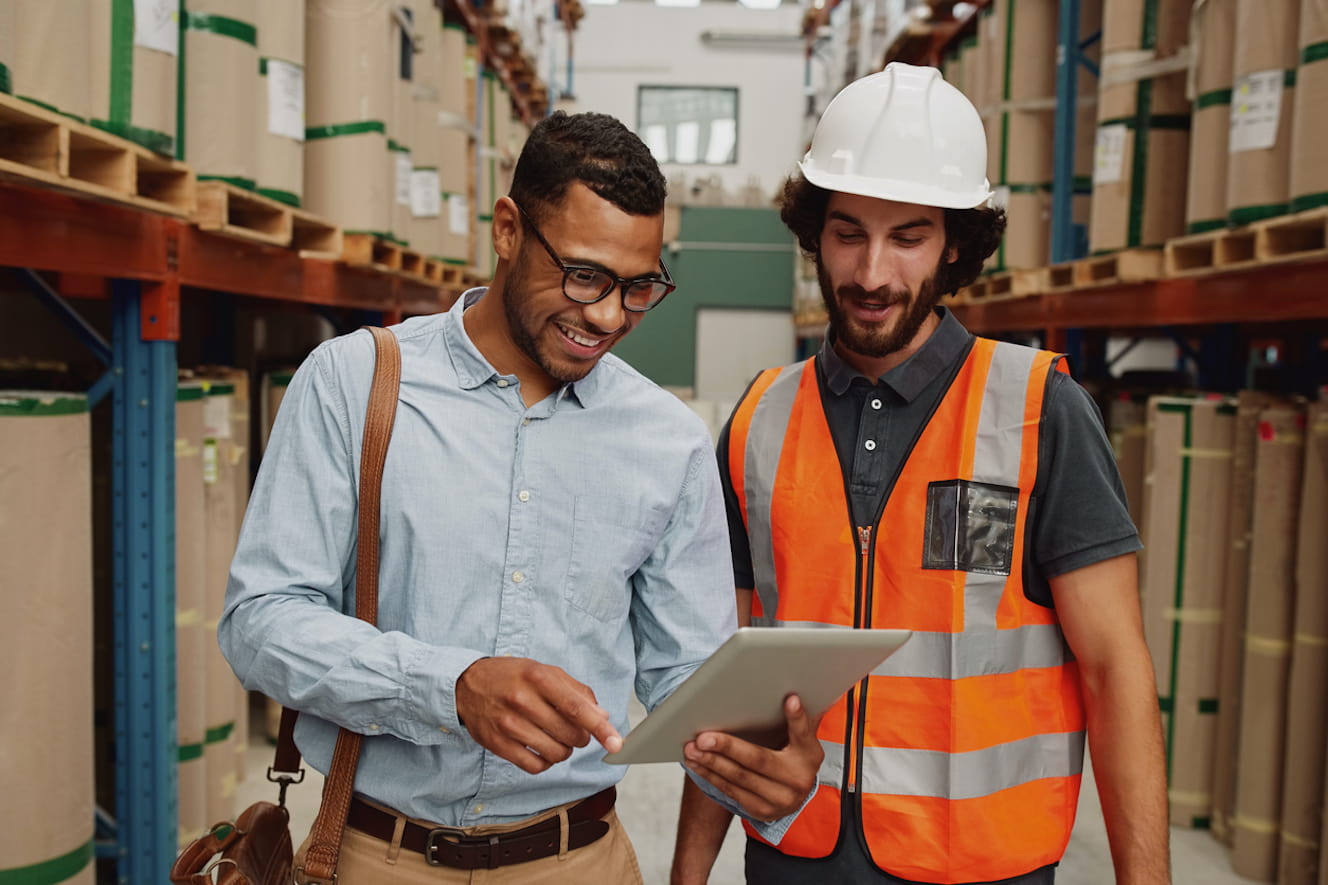 Two men stand in an aisle in a warehouse