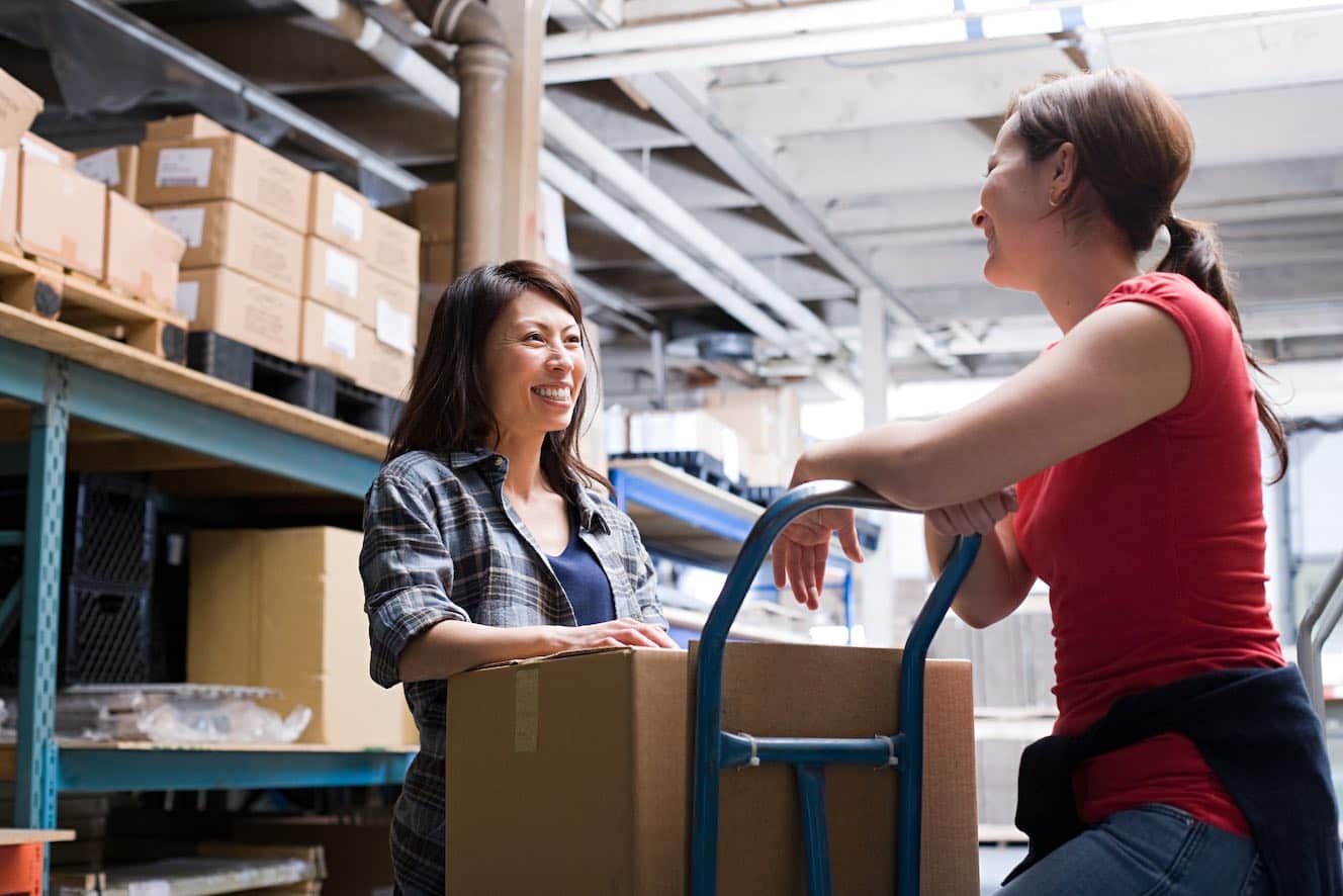 Two women smiling in a warehouse